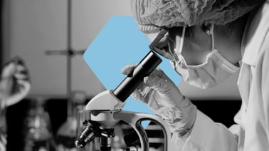 A scientist looking through a microscope